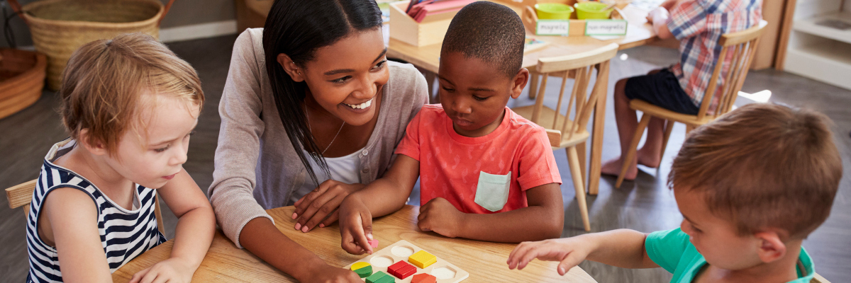 Photographic image of a childcare worker and a small group of children.