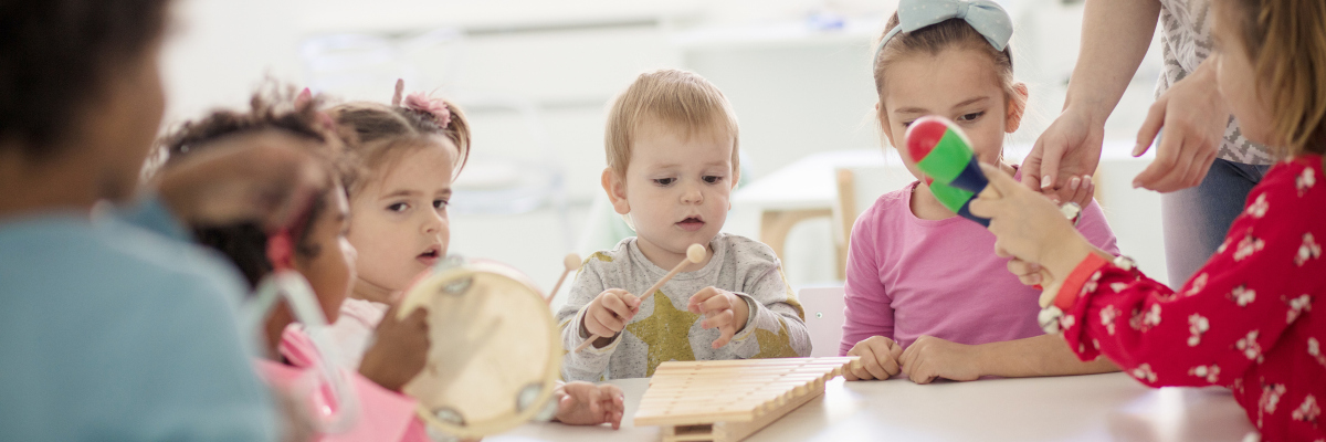 Photographic image of children looking at musical instruments together